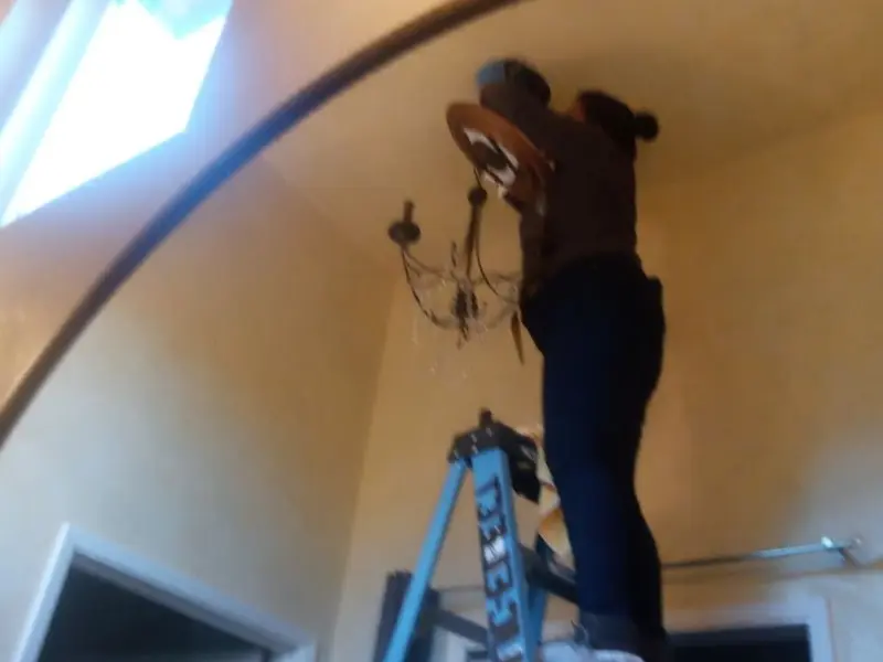 Electrician installing a chandelier in a Bethlehem residence